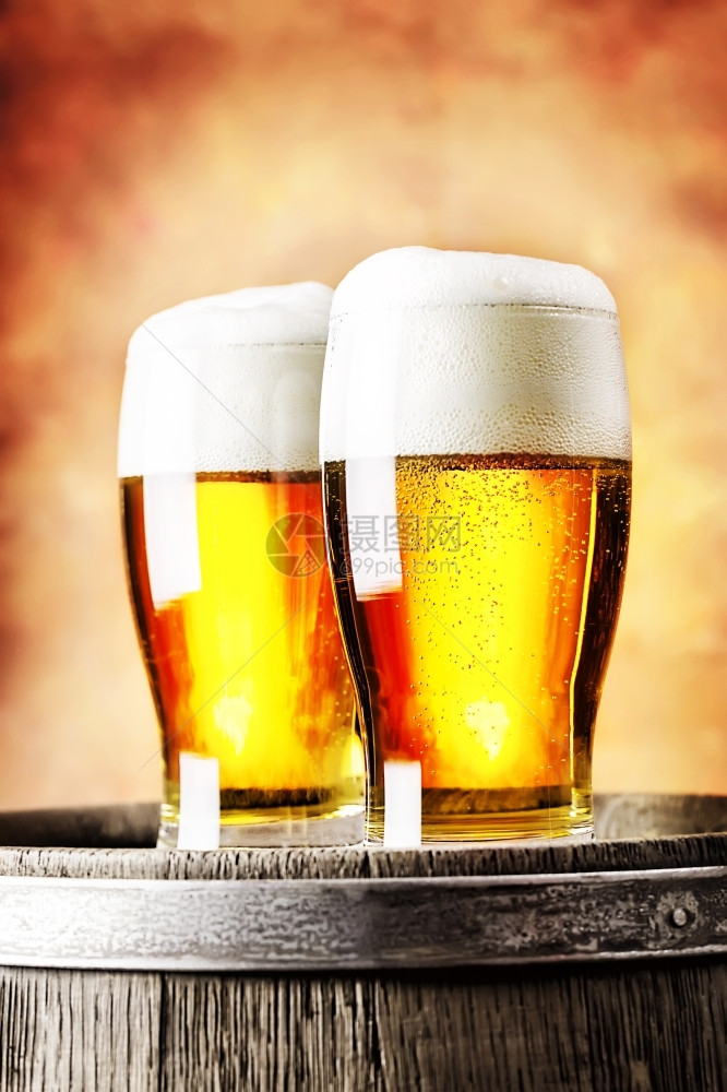 白色的马克杯眼镜两淡啤酒站在红色背景的木桶上两杯淡啤酒站在木桶上图片