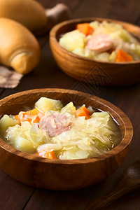用土豆胡萝卜和小木瓜做成碗用自然光拍攝的选择焦点第一道菜中间的聚焦乡村木制的炖背景图片