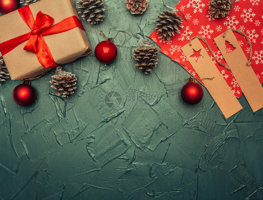礼物冬天圣诞节概念贺卡礼品箱圣诞玩具和锥体灰色背景的文字平铺空间卡片图片
