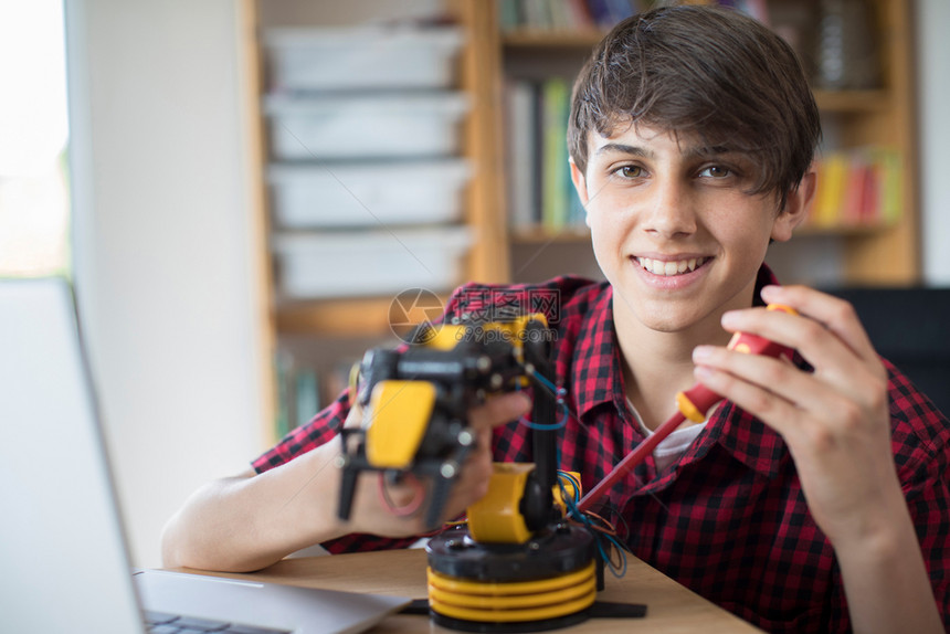 校内青少年男孩建造机器人臂的肖像在职白种人男图片