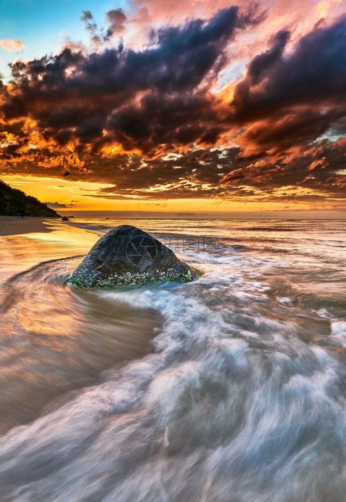 海边击打岩石的浪花与夕阳图片