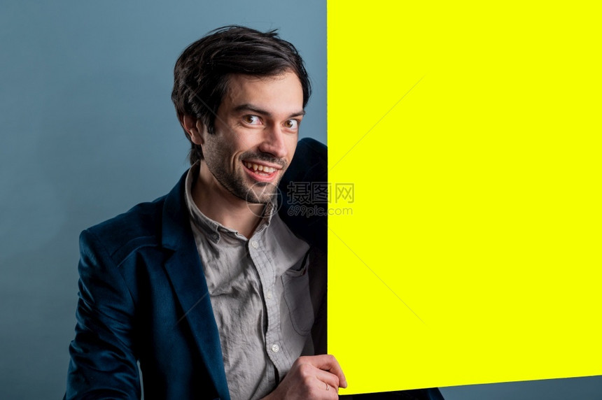 卡片手快乐的男人拿着一张黄色海报快乐微笑的年轻人展示空白招牌与的复制间区域用于标语或广告短信概念中的白种人男模横幅图片