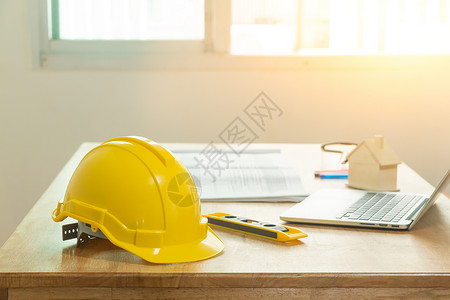 正面帽子黄色头盔在工程师办公桌上技术人员的安全头盔是工程师或建筑人学图片