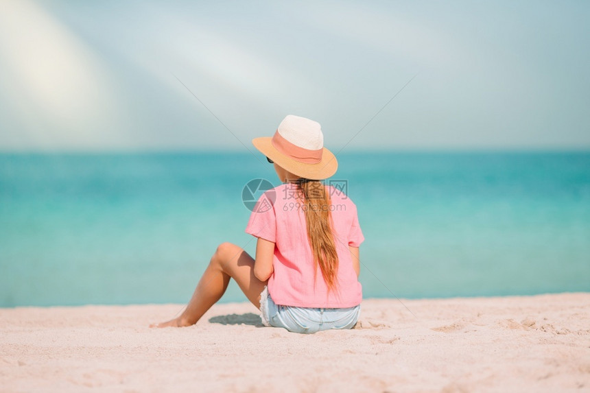 可爱的小女孩坐在海滩图片
