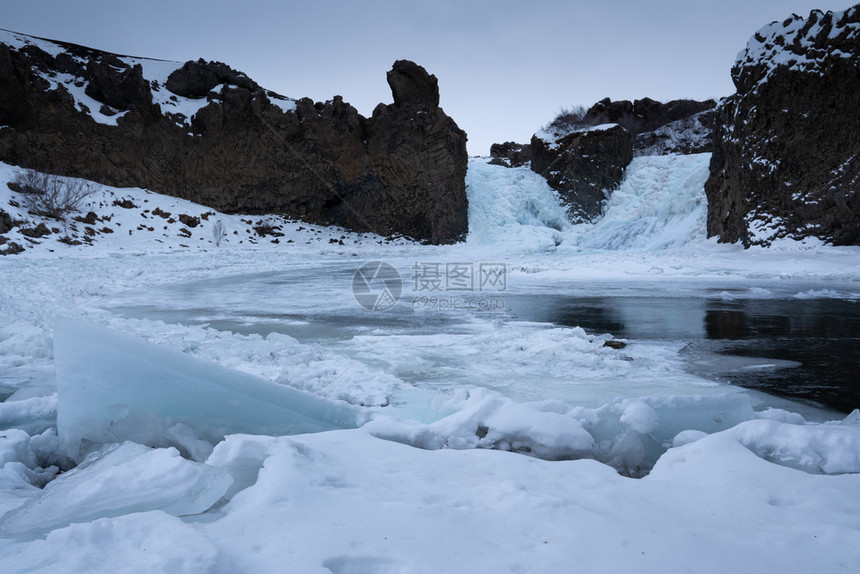 早晨冰冻的Hjalparfos瀑布在欧洲冰岛一个多云的清晨冬天公园风景图片
