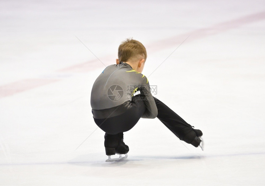 男孩式滑冰在带人工的滑场上刀积极的冷若冰霜图片