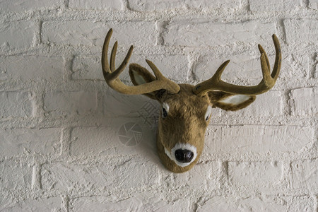 屋雕像装饰将鹿角挂在白砖墙上的人为雄鹿头图片