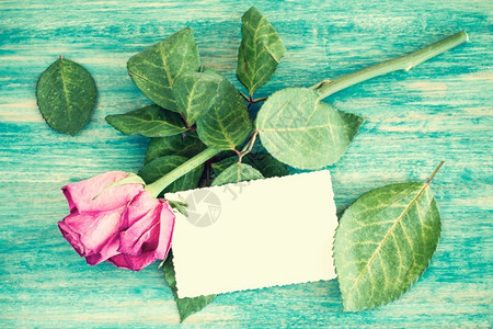 干玫瑰花束和空白贺卡在木制桌面上情人节卡片怀旧图片