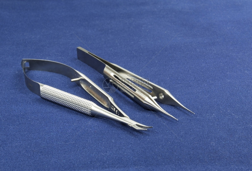工具蓝色背景侧边视图剪刀软曲线和带有平台的电压上两种显微外科仪器关心医生图片