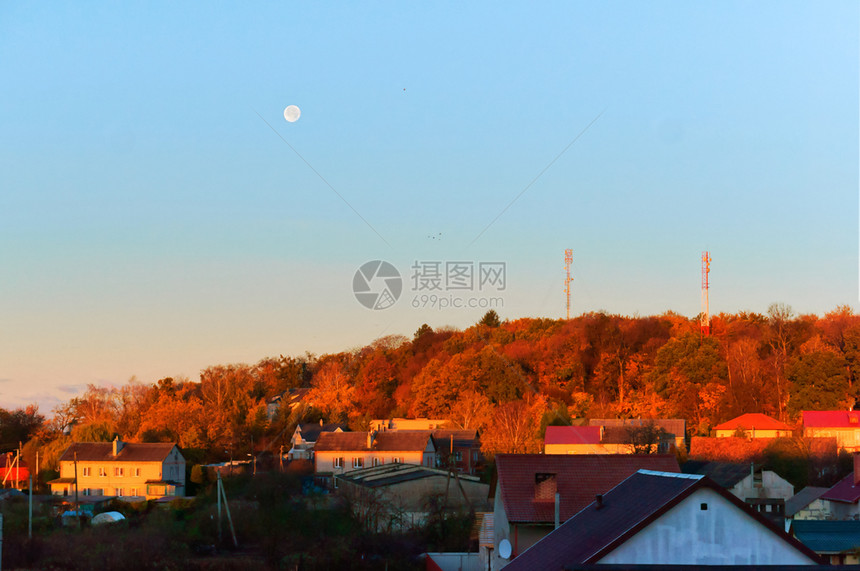 旅行自然月亮在黎明日落于家房屋顶上月亮在日落于家房屋顶上加里宁格勒图片