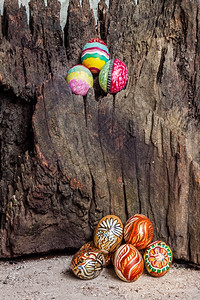 画粗糙的彩色全东方鸡蛋有旧褐色圆木季节图片