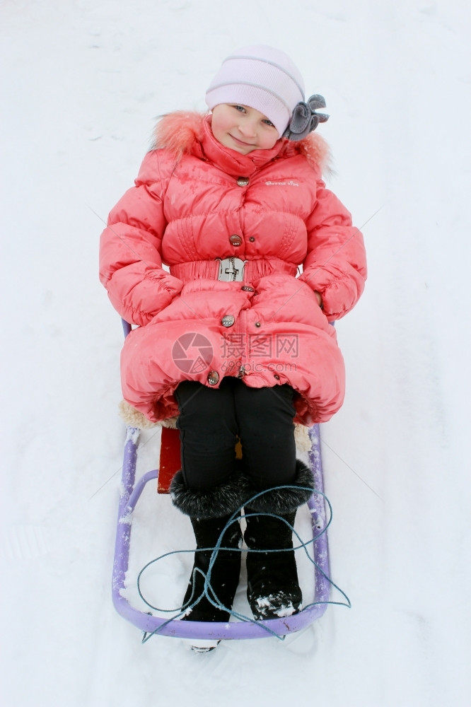 松弛生活坐在红色羽毛床上的雪橇漂亮女孩新图片