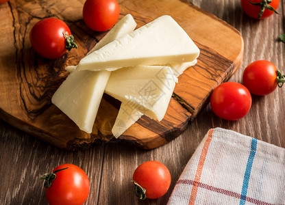 地中海木板上装有新鲜奶酪和番茄的切片希腊蔬菜图片