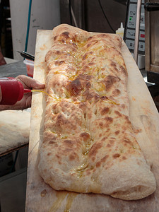 午餐法式面包自然把油倒在木板上的意大利佛卡夏面包上图片