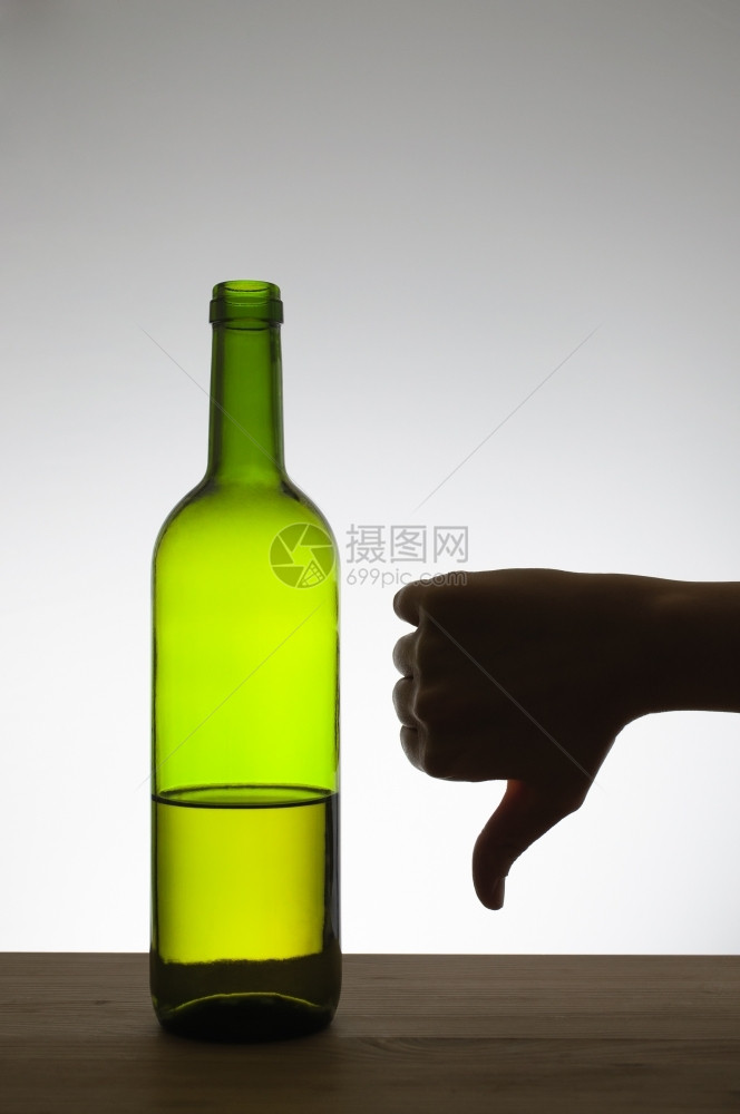 在一瓶酒旁边的手表下显示拇指的手影一种滴酒不沾点亮图片