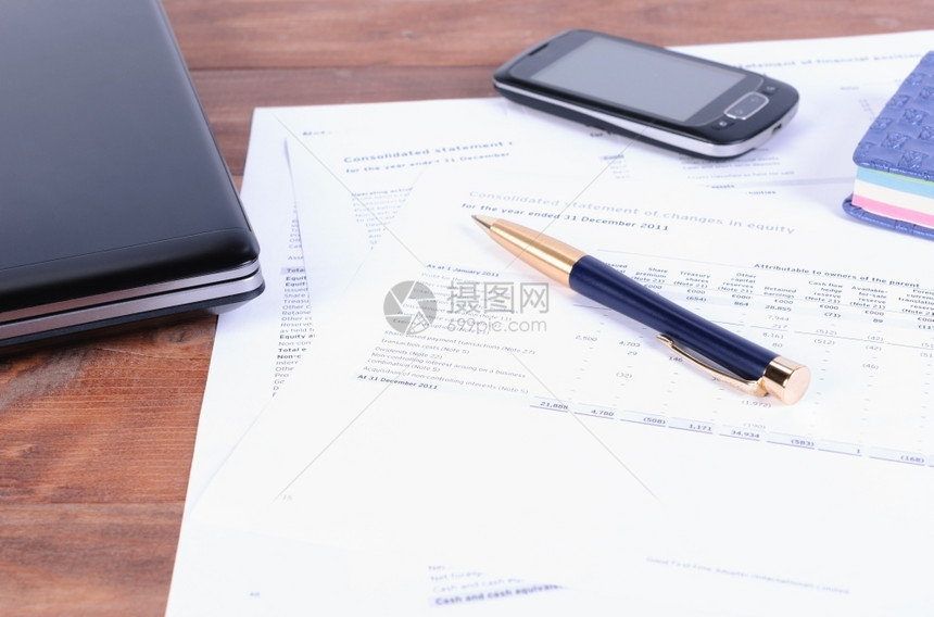 图表文档商务附件一支笔部电话和手提脑桌上有财务文件笔移动电话放在税务和财文件中办公室图片