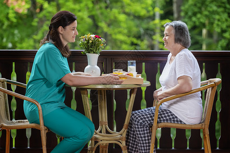 护理在养老院为快乐的年长妇女提供早餐给在养老院里幸福的年妇女食物关心图片