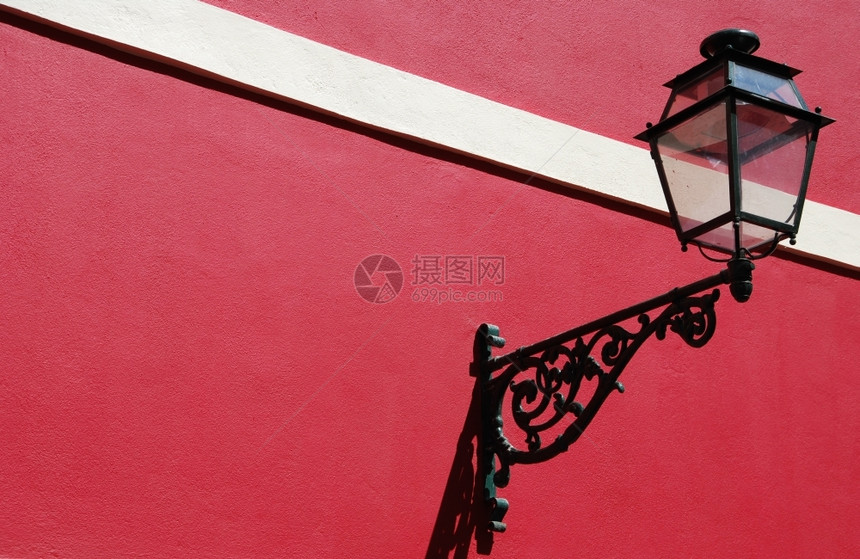 新鲜老式的经典红漆新墙壁建筑上的旧灯柱图片