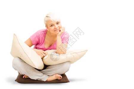 幸福手服装金发的天主教女人坐在地板上枕头悬在白色孤立背景上图片