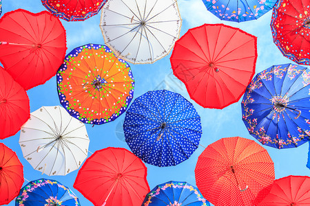 丰富多彩的在蓝天上挂着装饰伞的雨节日天空图片