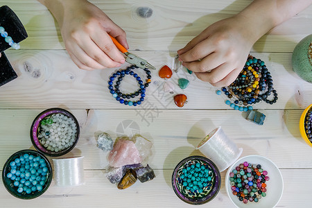 年轻女高视角野在家中手工制作晶珠宝项链和手镯珍珠女士美丽的图片