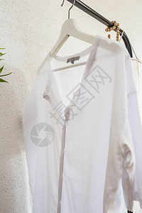 零售白色背景衣架上的白色衬衫时尚纺织品图片