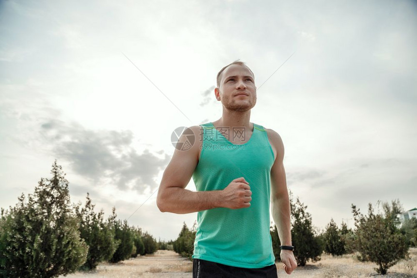 穿着蓝色T恤和黑短裤的白人男子日落时穿梭粗野地形训练运动型健康服图片