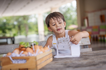 一个男孩子注意学习模拟机制在家里桌上的木制机器人模型板机支付白种人技术背景图片