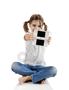 女控制器坐在地板上玩视频游戏的小女孩儿漂亮图片
