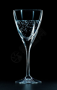 香槟酒水在黑色背景上隔绝的矿物水杯嘶声晶湿的背景