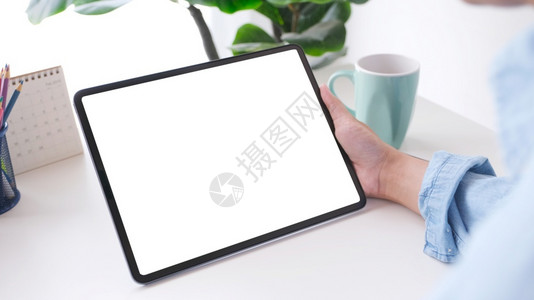 家药片小路近身手握数字平板电脑的人在工作桌背景上用黑白屏幕抓起数码平板进行模拟背景