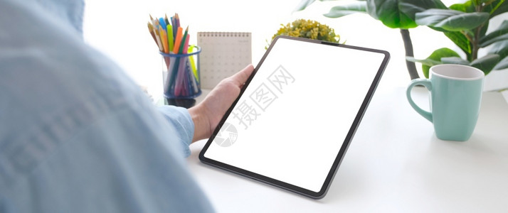 沟通近身手握数字平板电脑的人在工作桌背景上用黑白屏幕抓起数码平板进行模拟现代的白色背景