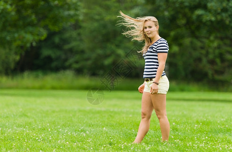 成人水平的公园里年轻女孩和风吹起她的头发图像以狭窄的田地深度颜色图片