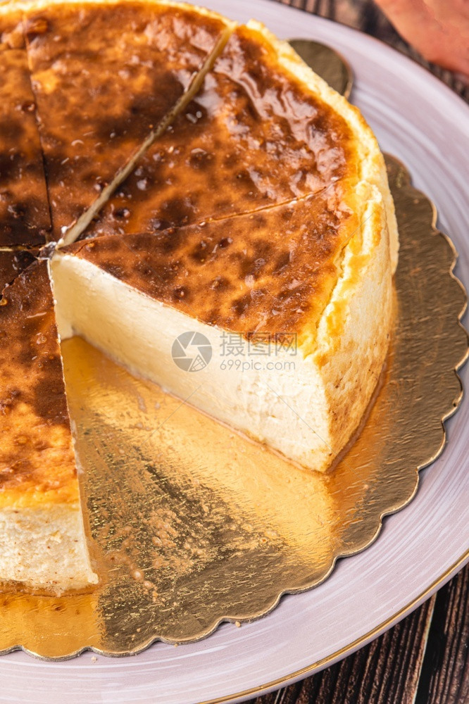 自制巴斯克法语切碎的桑塞巴斯蒂安芝士蛋糕和木制桌上的咖啡图片