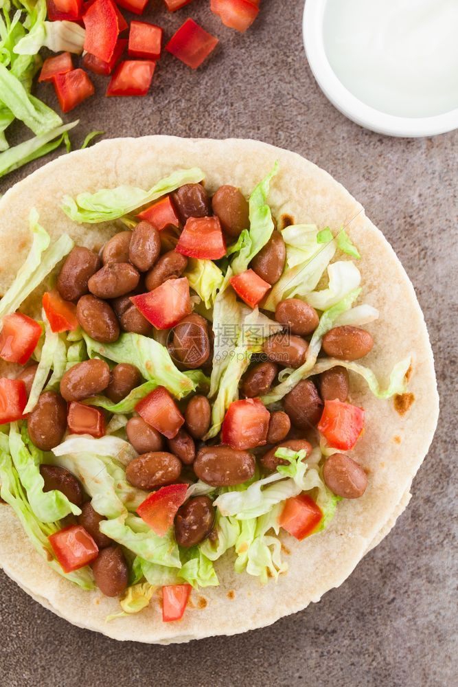 由面粉玉米饼生菜煮豆和西红柿制成的新鲜自素食玉米卷饼对上方进行拍照选择焦点重是用豆类白菜和番茄填充玉米面粉花生和番茄制作健康小麦图片