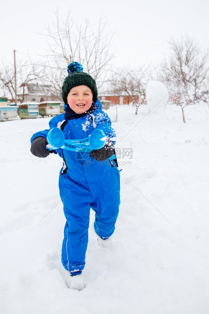 雪地里玩耍的小男孩图片