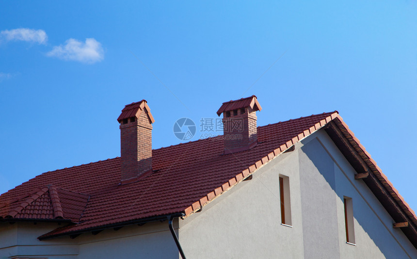 房子有砖烟囱阳光明亮面对深蓝色的天空在房顶上的香尼丝在蓝天窥视白屋图片