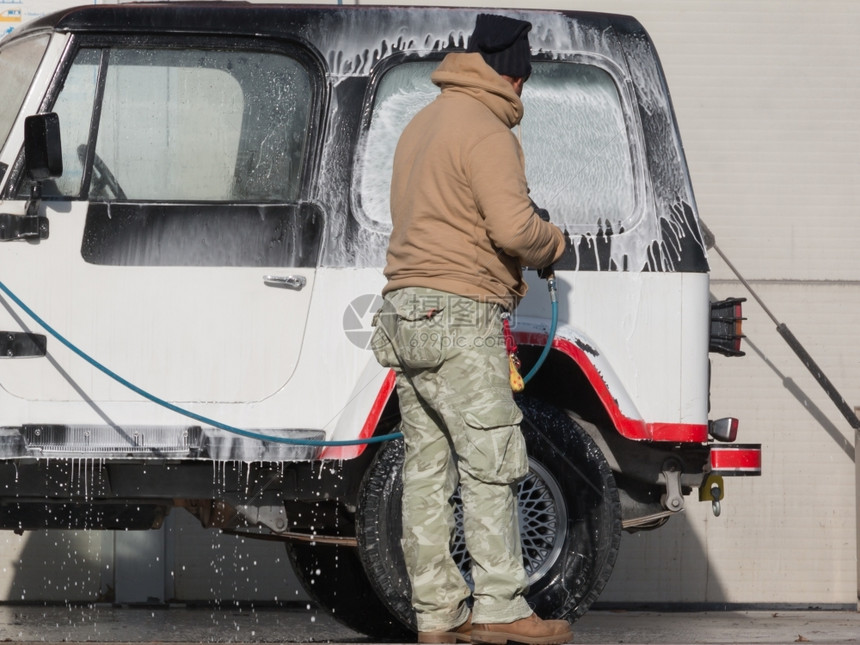 肥皂男人用喷水和洗发车户外干净的图片