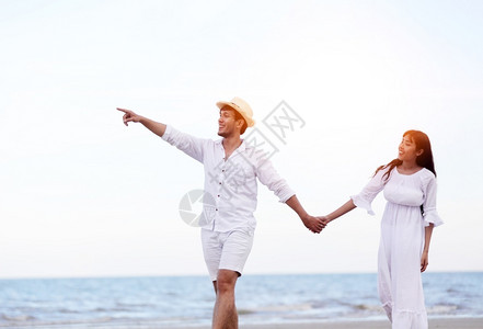 海滩上手牵手散步的夫妻图片