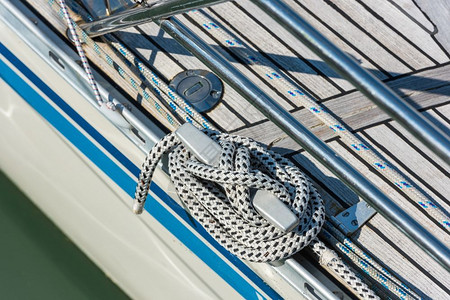在游艇一侧用绳子和缠结的尾端捆绑在领带上漩涡扭曲的细节图片