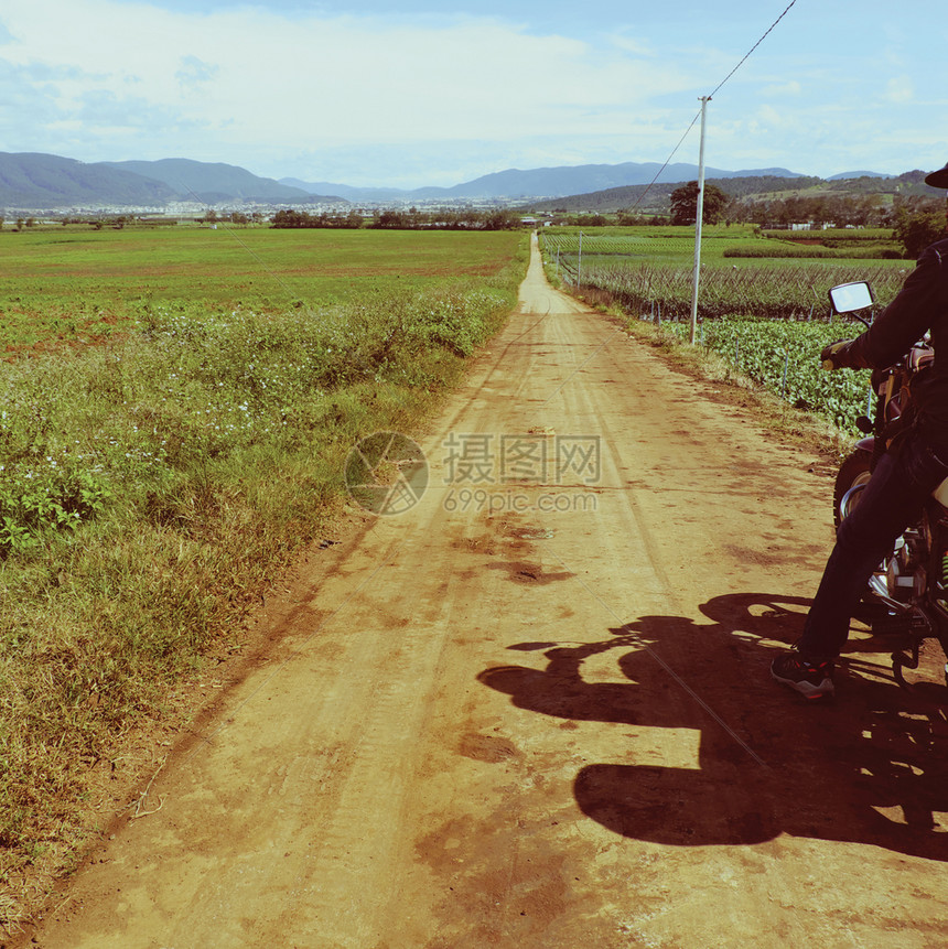 亚洲人优质的男子佩戴头盔在越南乡村公路上骑摩托车长途旅行背包人冒险向前图片