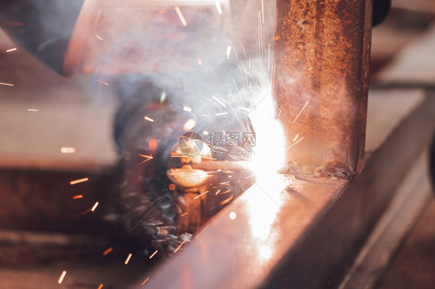 行业面具工人两个金属零件焊接过程特写工业背景两个金属零件焊接过程特写图片