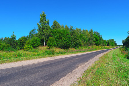 穿过树木灌丛和草地的空高速公路夏天冒险度图片