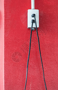伏特连接白色塑料插座在办公大楼的红色柱子上安装有电线的白塑料插座质地图片