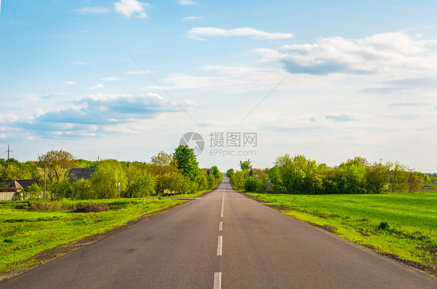 旅行在春夕阳途经农村的横贯乡干道草小路图片