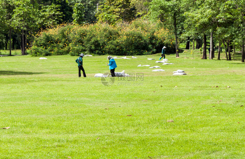 草地工人在城市公园草坪上从采机中集花园在职的图片