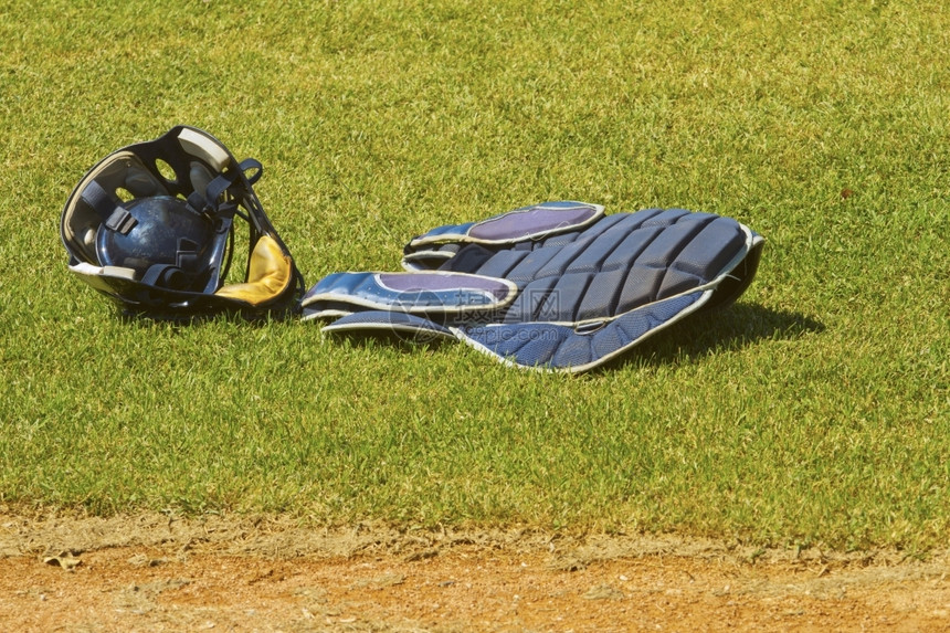 专业的皮革在棒球场草地上戴面罩的捕猎者服装投手图片