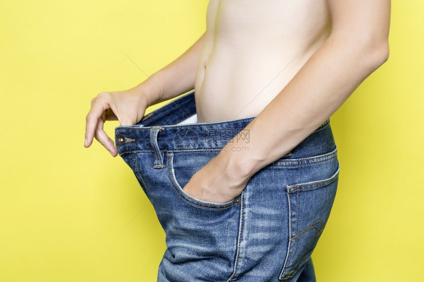 饮食适当营养减肥的概念穿着宽松牛仔裤的苗条女人和穿着黄色背景的超大牛仔裤瘦女人饮食减肥的概念穿着宽松牛仔裤的苗条女人和穿着超大牛图片