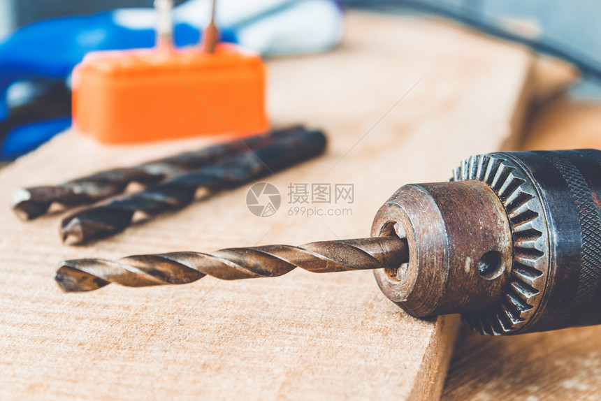 修理工业的木制背景上电钻头工具和维修作的概念钻头在木制背景上的电钻中头工具和维修作的概念颜色图片