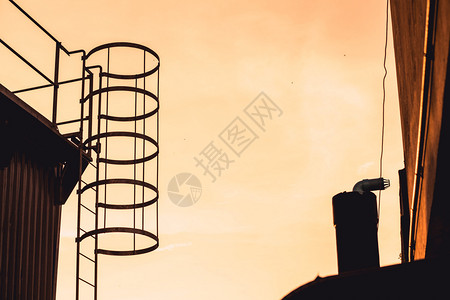 工业的环境程仰望梯子在冷却塔的轮环上图片